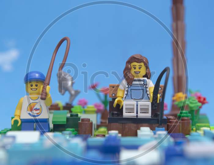 Florianopolis, Brazil. September 20, 2020: Front View Of Mini Figure Happy Mother And Son Fishing By The River. Child Catching A Big Fish With His Fishing Rod. Time To Relax. Selective Focus.
