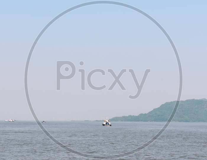 A Small Boat Moving In A Vast Blue Ocean Near Mumbai