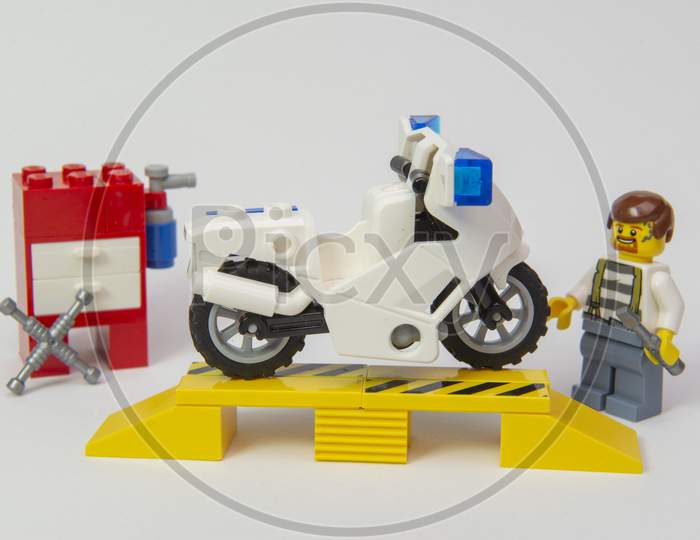 Florianopolis, Brazil. September 19, 2020: Grease-Dirty Mechanic Minifigure Repairing A Motorcycle On White Background. Motorcycle In Need Of Repair. Copy Space. Selective Focus.