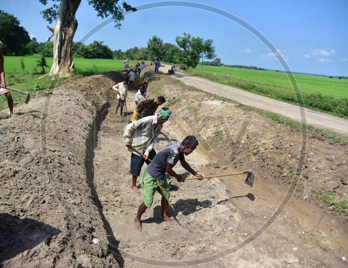 Labourers dig a canal along agricultural fields at a village in Nagaon district of Assam, Thursday, Oct. 1, 2020.