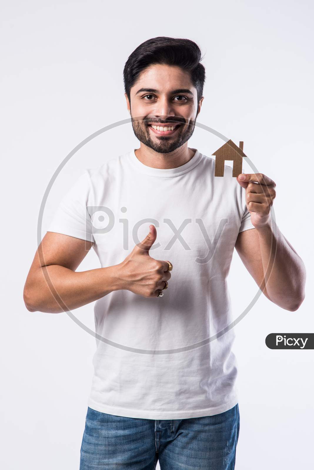 Real Estate Concept - Indian Handsome Man Holding Cut Out Of Paper House Model