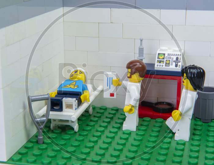 Florianopolis, Brazil. September 19, 2020: Doctor Minifigure Delivering Prescription Medication For Pain Relief To Patient Lying On Stretcher In Hospital After A Car Accident.