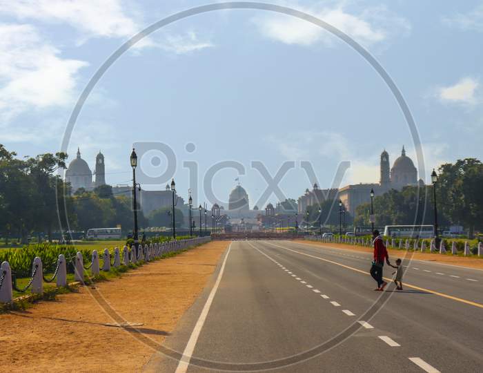 FATHER AND SON CROSSING ROAD IN FRONT OF RASHTRAPATI BHAVAN DELHI, INDIA OCTOBER 2ND 2020