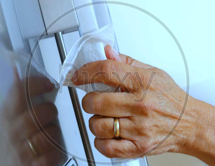 Woman Hand Doing Chores In The Door Handle Against Corona Virus