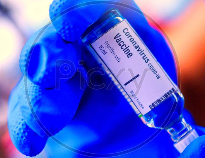 Image Of Hand Holds Corona Virus Covid-19 Vaccine Glass Bottle.