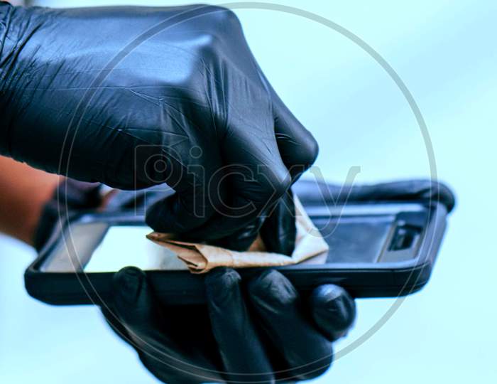 Man In Gloves With Cleaning Smart Phone.