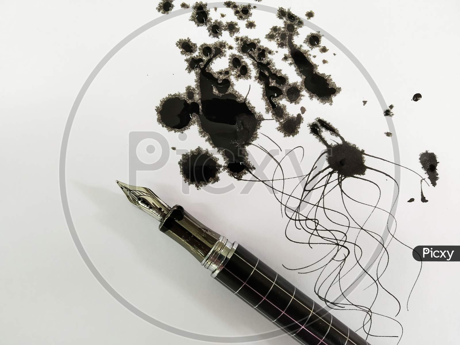 A Ink Pen With Black Ink Spread On Paper