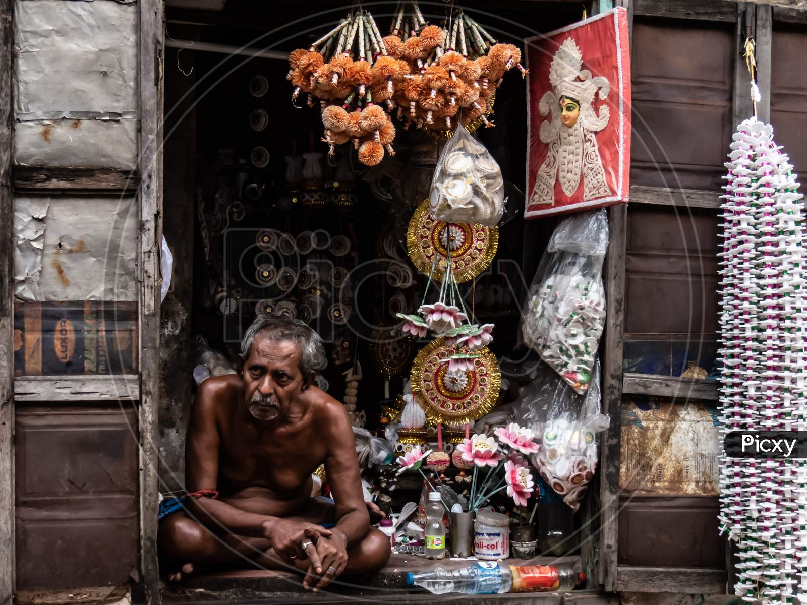 Old Man At His Shop Selling Puja Related Things.