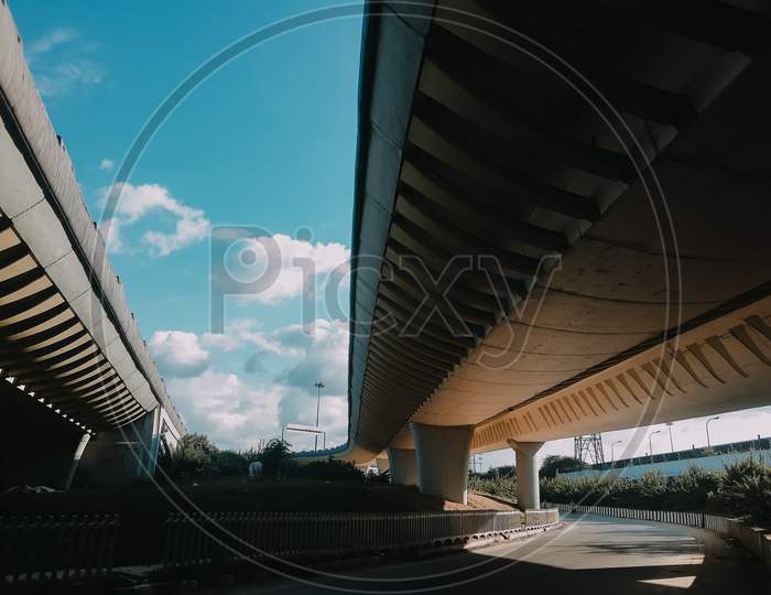View Under A Concrete Road Bridge. Bridge Supports Across The River Near Signature Bridge Yamuna River At Wazirabad Section