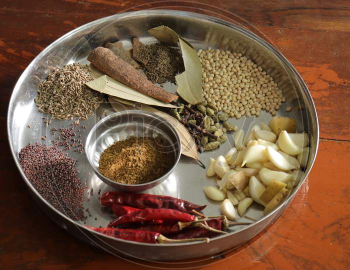 Various herbs and powder spices steel plate on black background top view