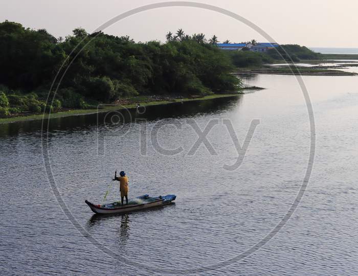 In The Morning, A Fisherman Rode In A Wooden Boat To Catch Fish From The Lake Of Water.