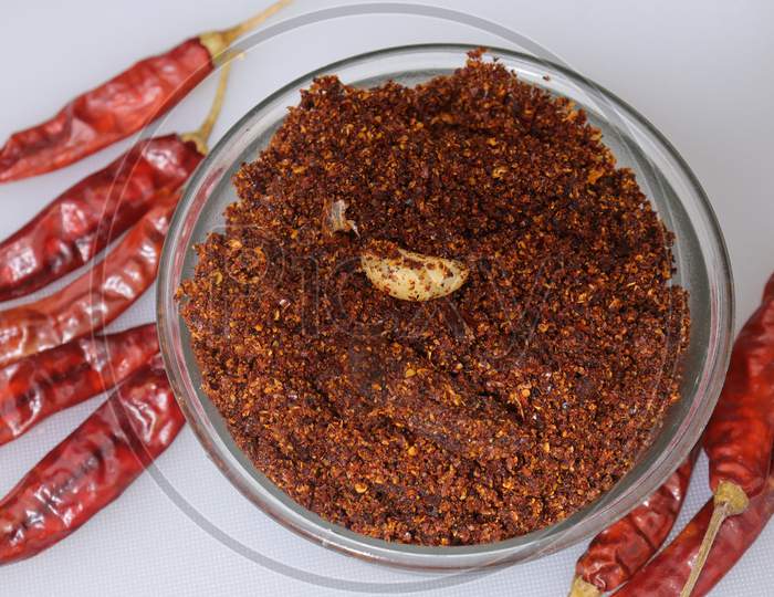 Dry hot red chillies powder on white background from top view.