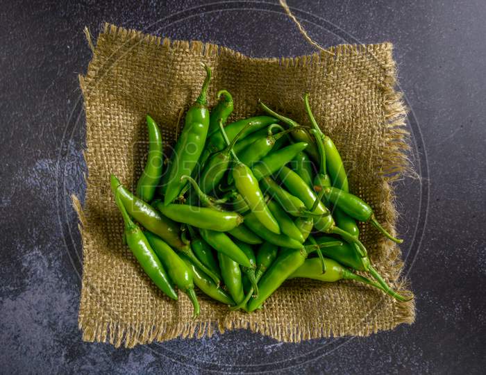Green Chilly On Wooden Background.Fresh And Raw Green Chili Isolated