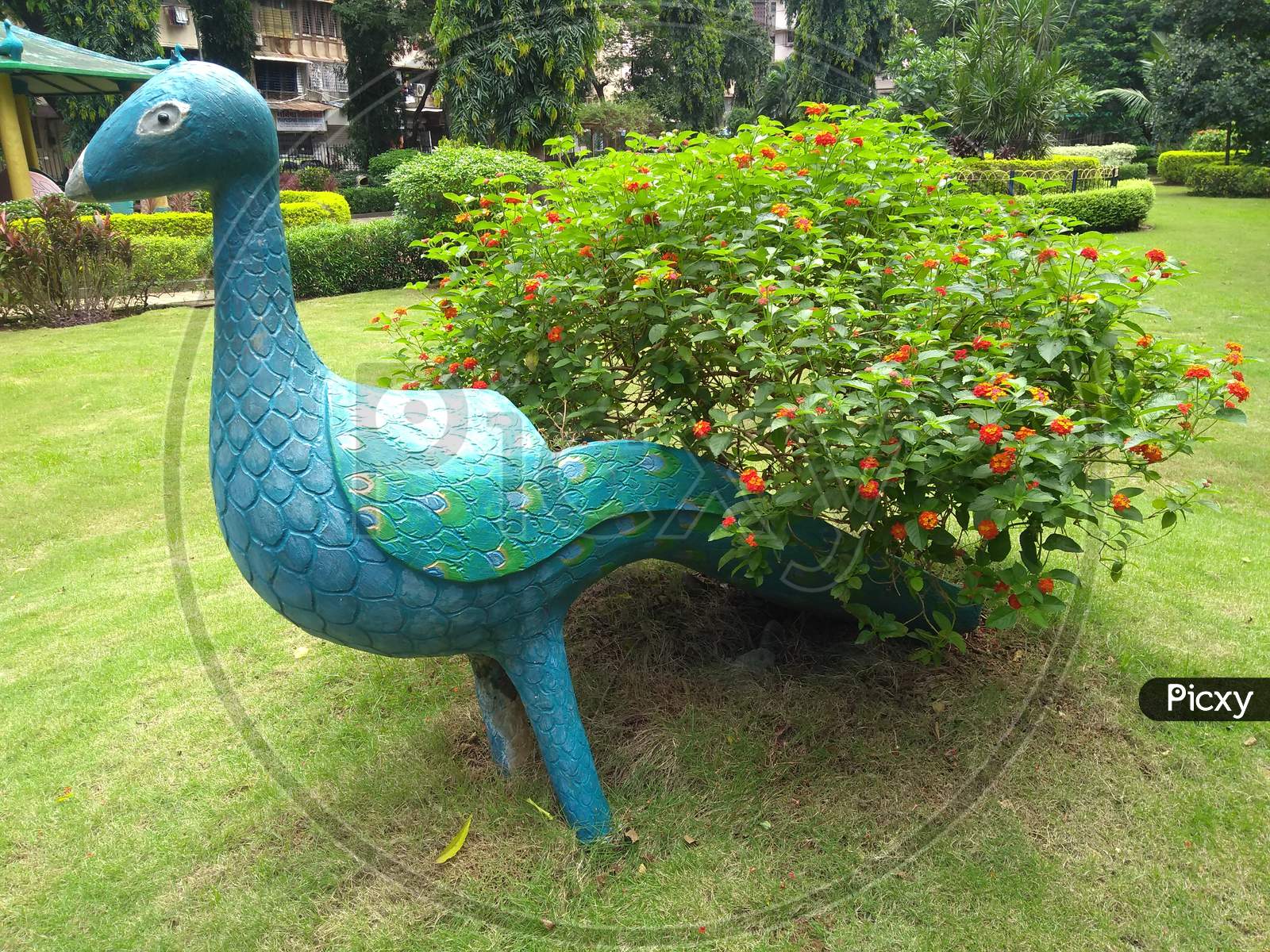 Artificial Peacock With Tree Tail In The Greenery Filled Garden.