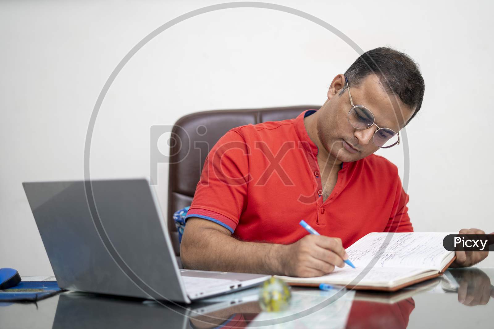 Technology, Remote Job And Lifestyle Concept - Happy Indian Man In Glasses With Laptop Computer Working At Office.