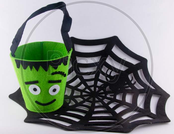 Halloween Fun For Kids Going Out To Trick Or Treat. Green Monster Candy Bag On Black Spider Web With Copy Space