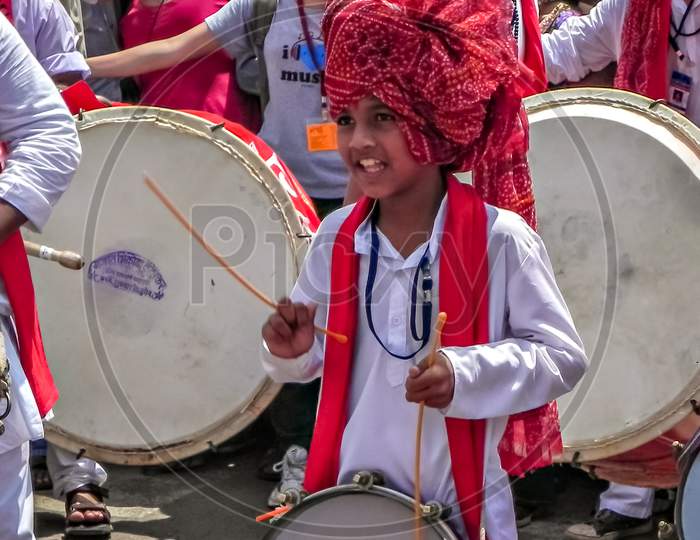 Little Boy With Red Turban Beating Traditional Tasha During Festival Procession.