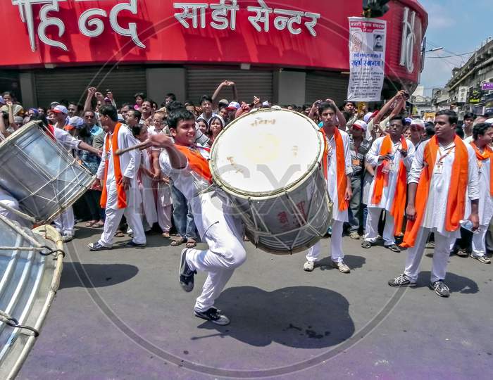 Youth Beating Huge Traditional Dhol During Ganesh Festival As The Crowd Watches.