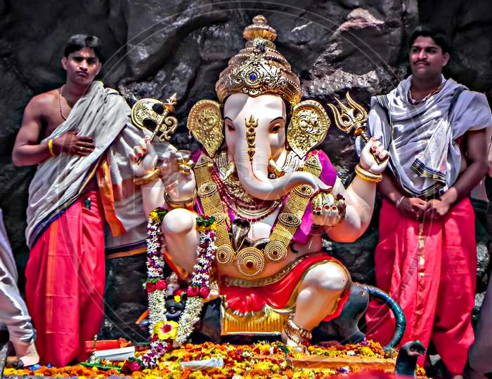 Decorated and garlanded huge idol of Hindu God Ganesha during festival procession.