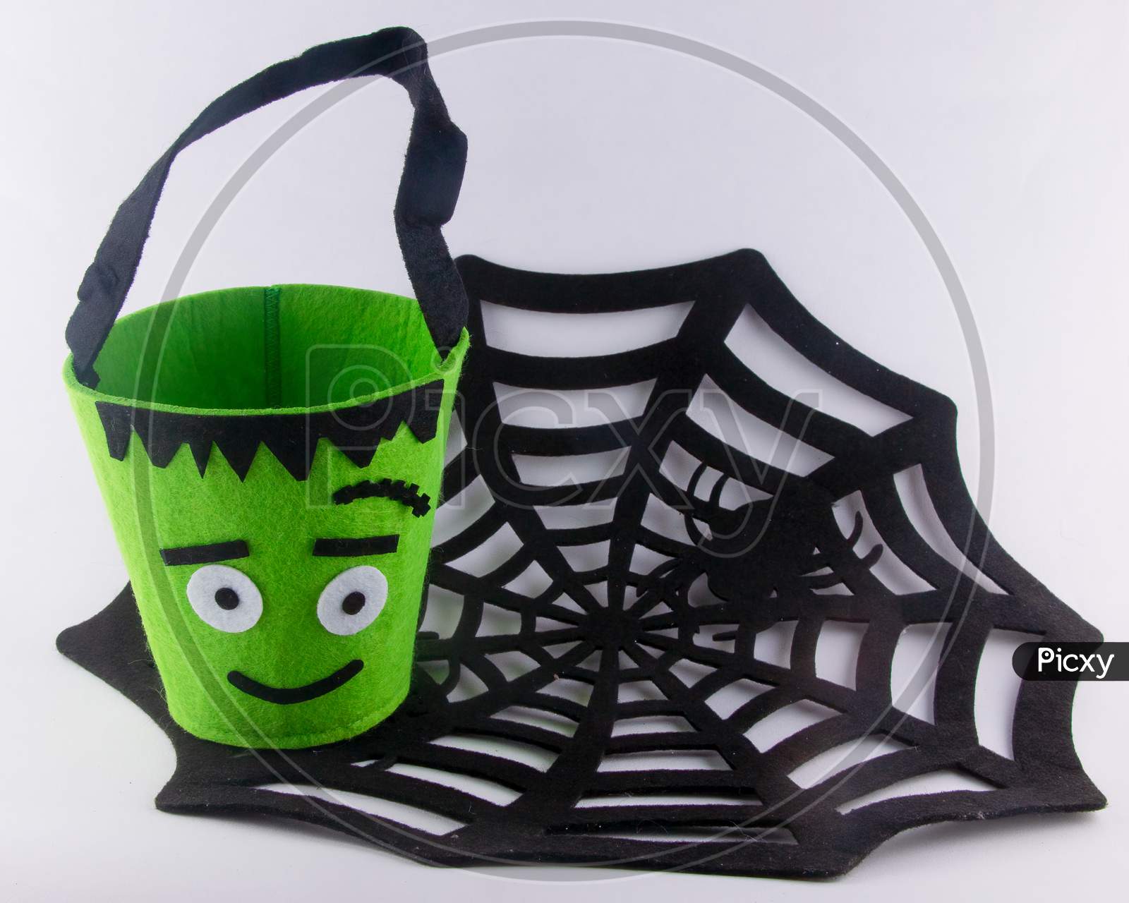 Halloween Fun For Kids Going Out To Trick Or Treat. Green Monster Candy Bag On Black Spider Web With Copy Space