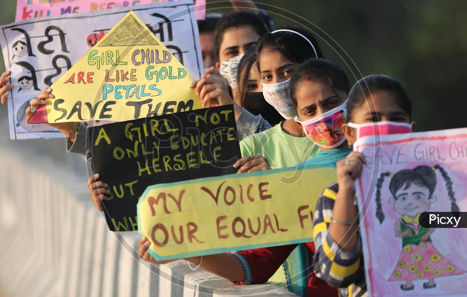 A Group of girls hold playcards ahead of International girls child day in Jammu ,10 october.2020.