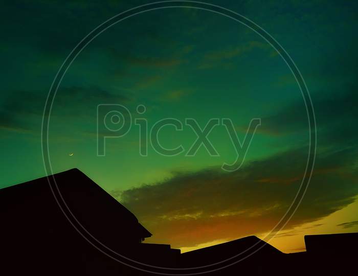Beautiful sunset at village with silhouette landscape green orange sky and cloudscape