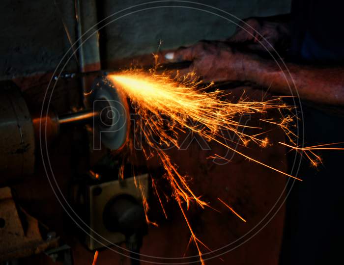 Mechanic working on grinding machine sparking elements