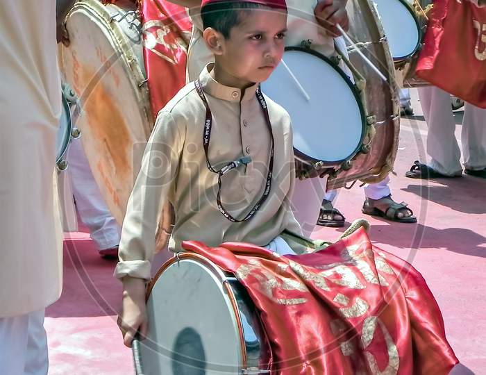 Little Boy With Red Cap Beating Huge Traditional Dhol During Ganesh Festival.