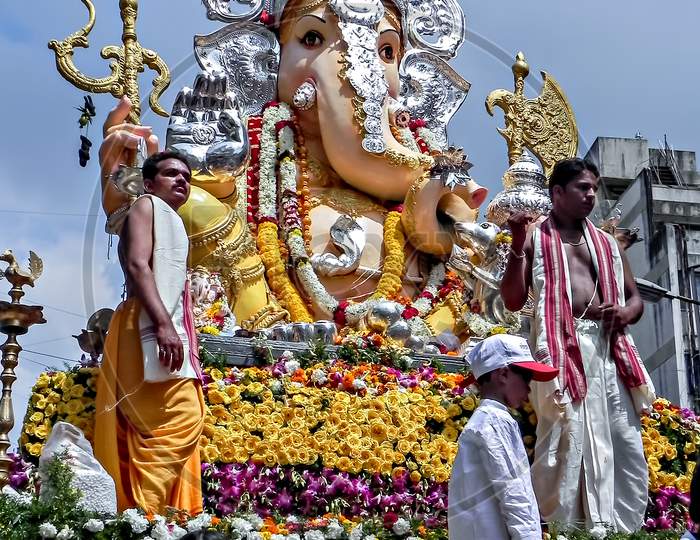 Decorated and garlanded huge idol of Hindu God Ganesha during festival procession.