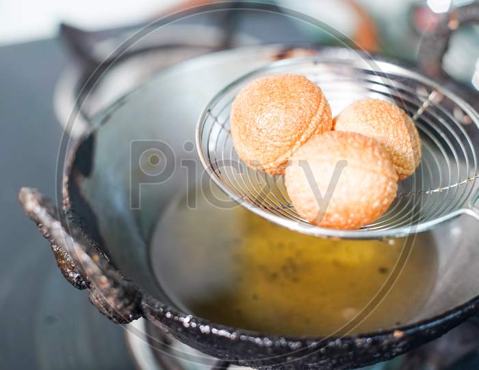 Shot Of North Indian Street Food Snack Gol Gappe Pani Puri Or Puchke Being Fried From Dough In Hot Oil To Make Them Round Hollow Golden Ball Spheres