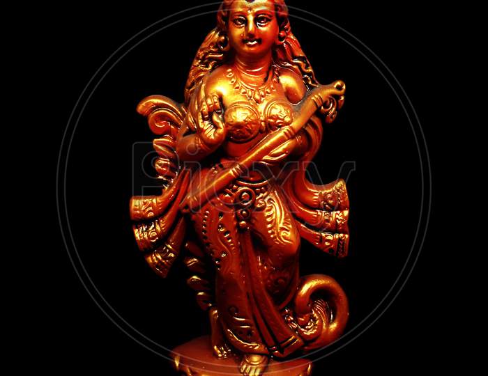 Hindu goddess of education mother Saraswati statue on black background