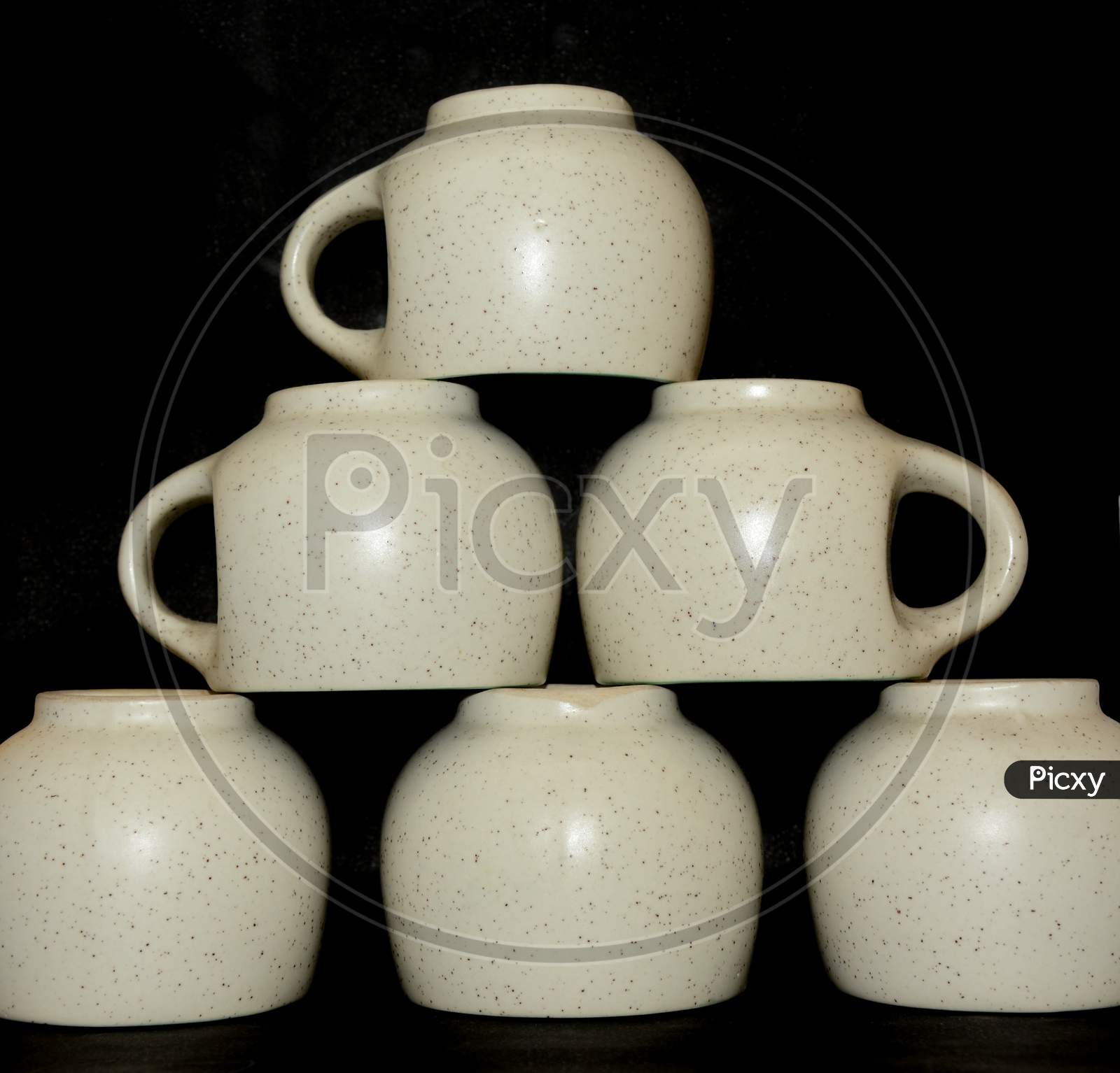 Close up of tea cup set, dotted cups, selective focus, black background.