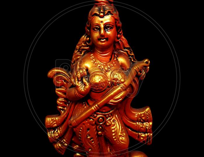 Statue of Hindu goddess of education Saraswati on black background