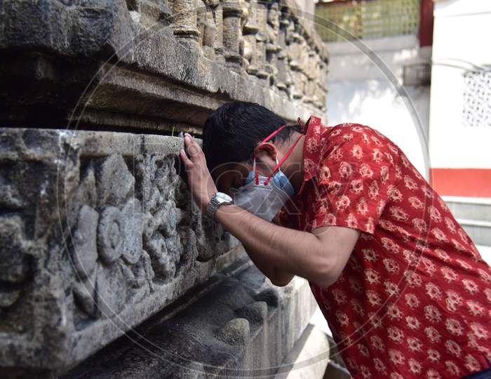 Indian devotees offer prayers by touching the Kamakhya temple after re-opens for public after a gap of nearly six months due to coronavirus lockdown with certain restrictions, in Guwahati, India on October 11, 2020.