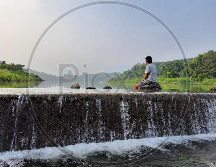 Man sitting on rock in the river