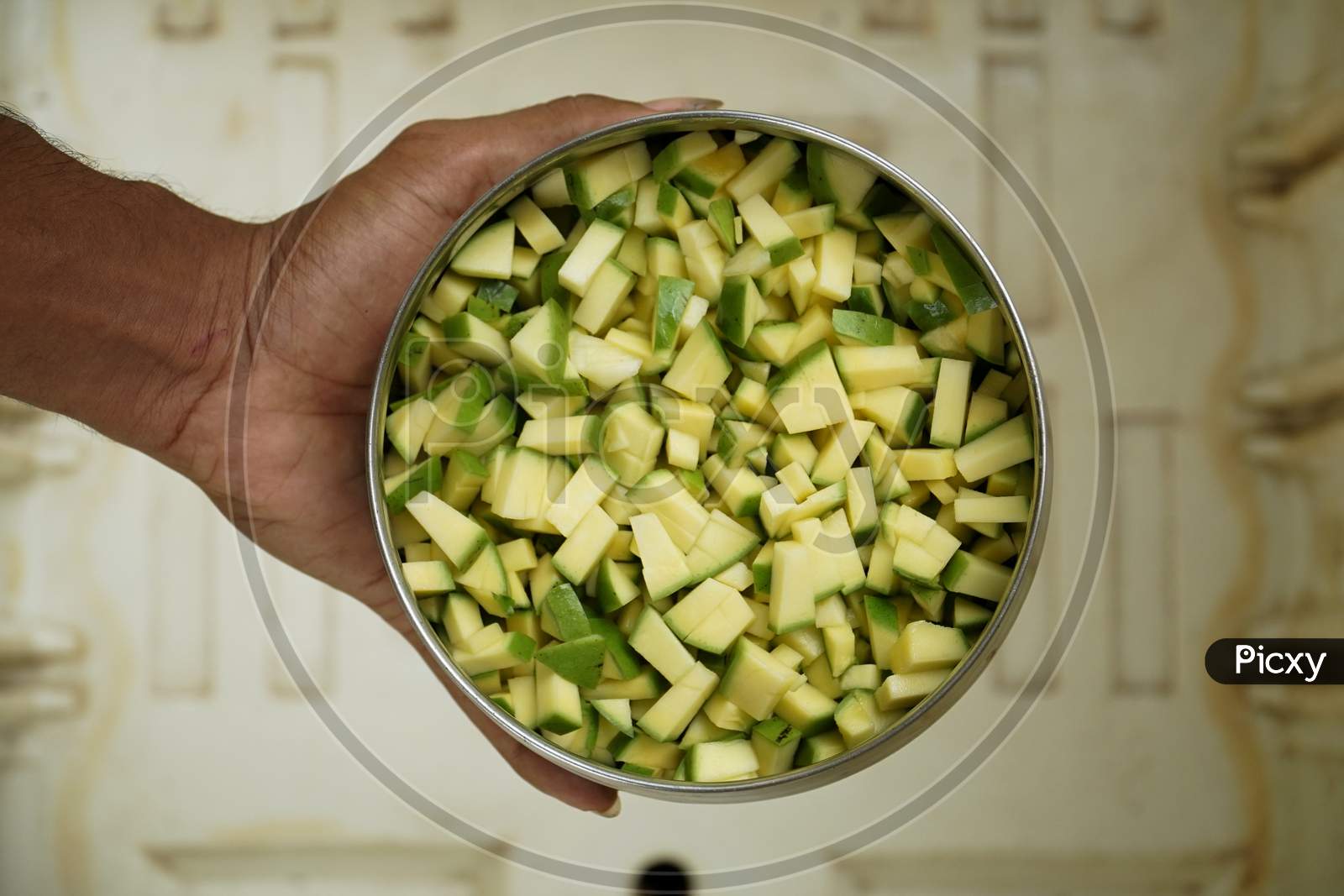 Close Up Image Of Fresh Chopped Green Mango Pieces For Cooking In A Stainless Steel Bowl.
