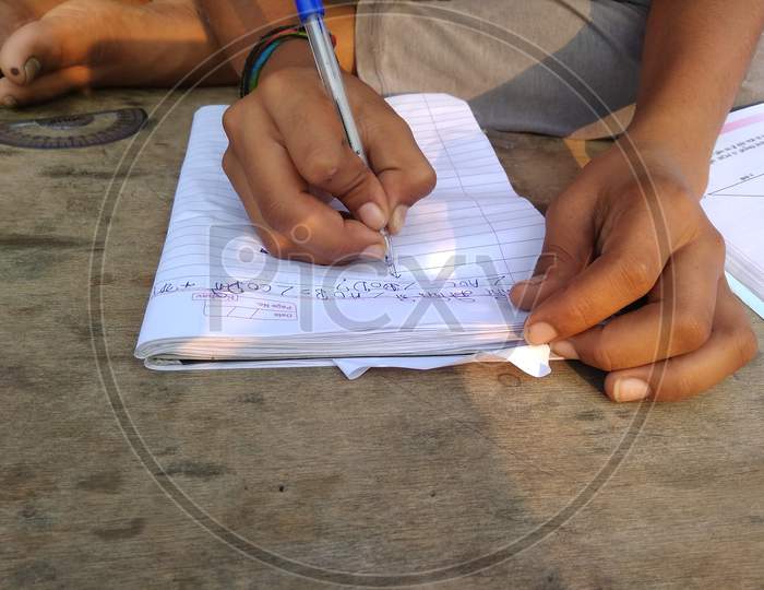 School kid writing on workbook