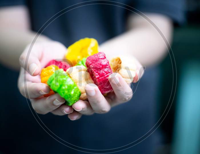 Young Indian Woman Holding Colorful Fried Food Made Of Potato Starch And Sago Called Far Far Fryums Which Is A Popular Food In North India Or A Great Snack