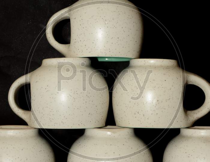 Close up of tea cup set, dotted cups, selective focus, black background.