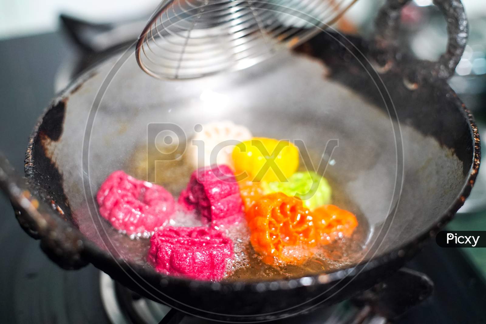 Shot Of Colorful Fryums Being Deep Fried In Hot Oil Bubbling And Sizzling With Bubbles Forming And Size Increasing Of This Popular North Indian Snack And Street Food
