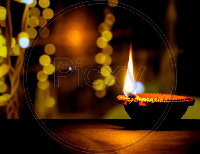 Clay Diya Candle Illuminated In Dipavali, Hindu Festival Of Lights. Traditional Oil Lamp On Dark Background