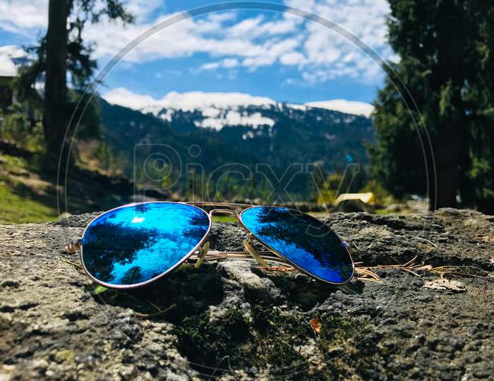 Aviators on rocks with mountains behind