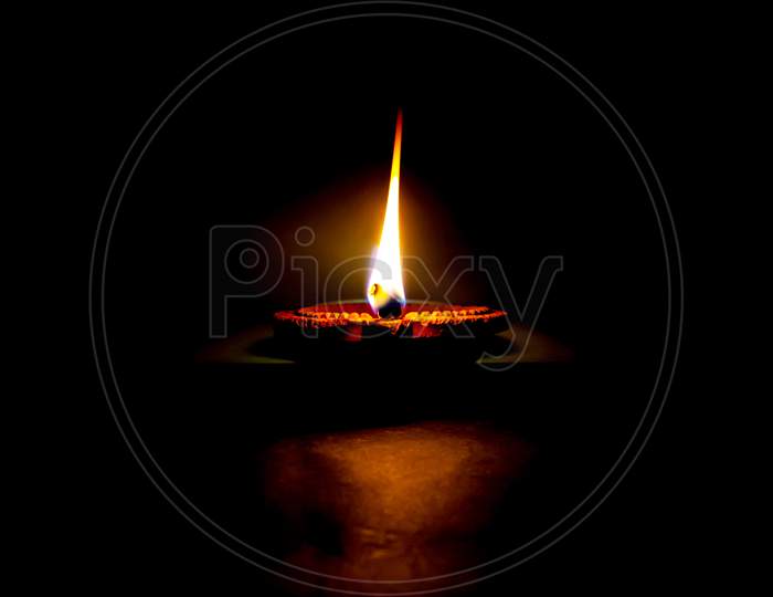 Clay Diya Candle Illuminated In Dipavali, Hindu Festival Of Lights. Traditional Oil Lamp On Dark Background