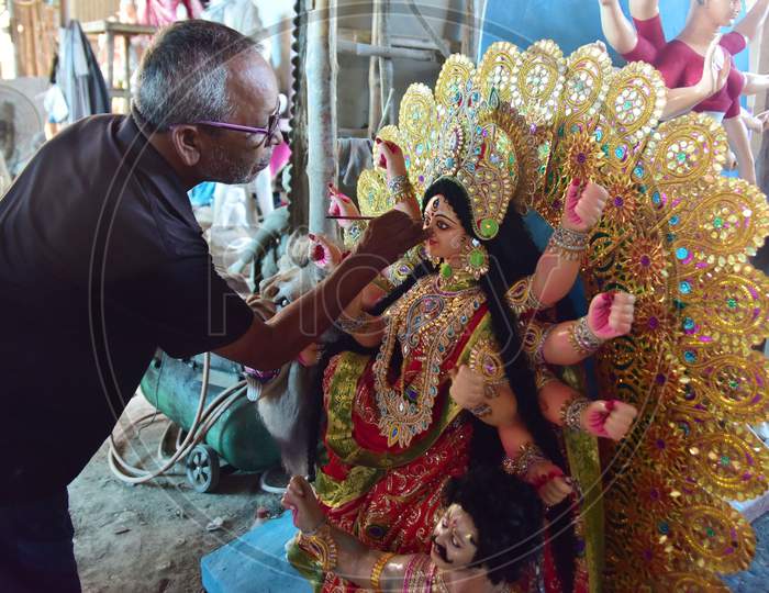 An artisan gives finishing touches to a clay sculpture depicting Hindu goddess Durga at a workshop ahead of the upcoming 'Durga Puja' festival, in Guwahati on October 13, 2020