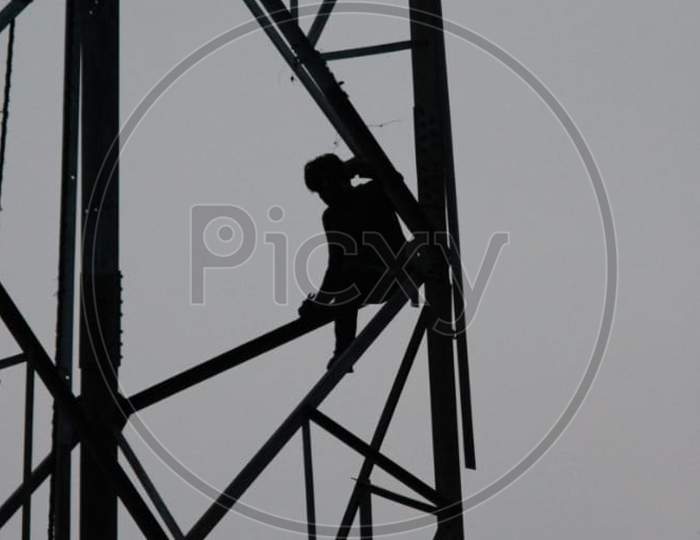 picture of a man working on the top of a tower