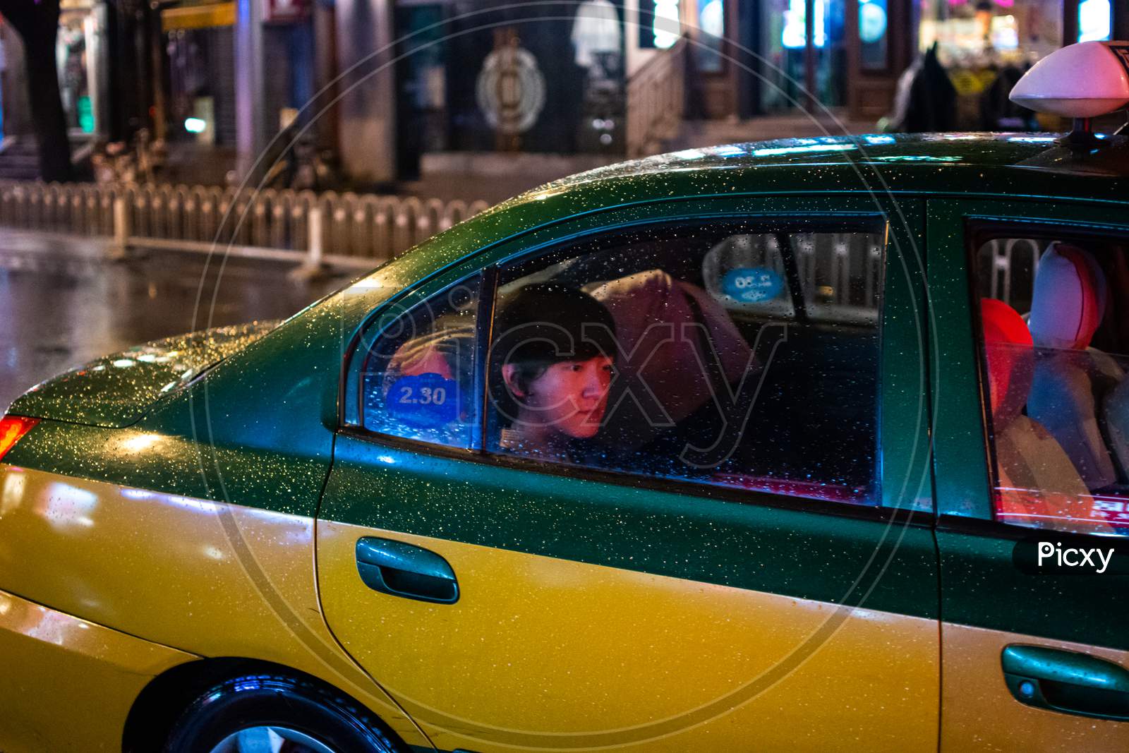 Passenger Taking A Ride On A Beijing City Taxi On A Rainy Night In China