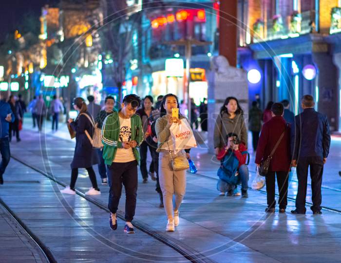 People Stroll Along The Historic Qianmen Street South From Tiananmen In Beijing