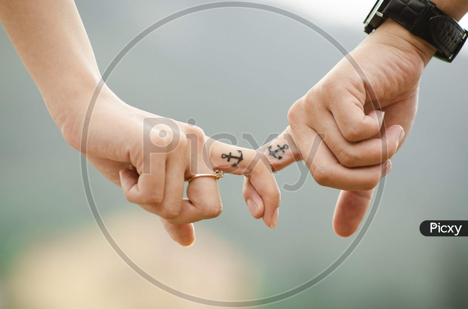 Image of two couple holding their finger.