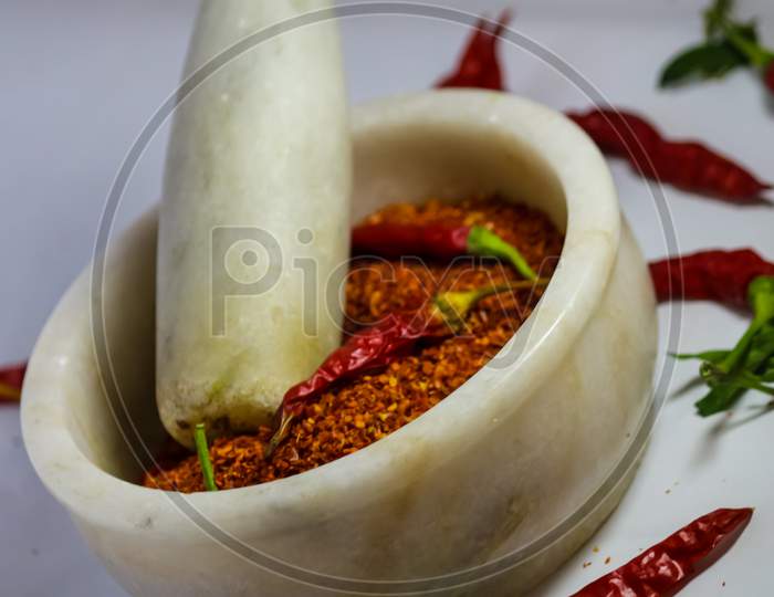 Red chillies and red chilli powder in the pestle mortar