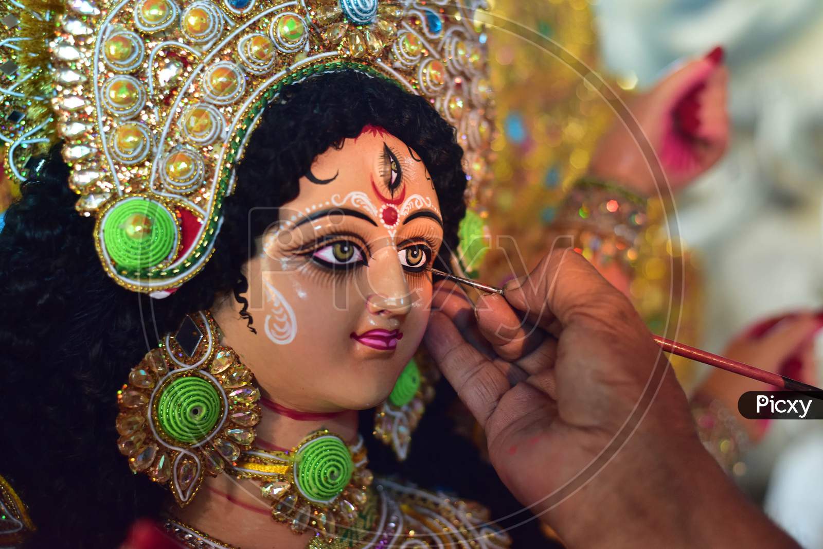 An artisan gives finishing touches to a clay sculpture depicting Hindu goddess Durga at a workshop ahead of the upcoming 'Durga Puja' festival, in Guwahati on October 13, 2020